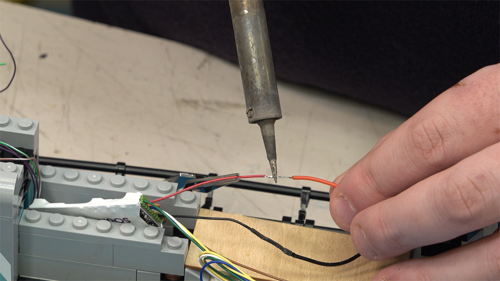 Two red wires are soldered together inside the locomotive