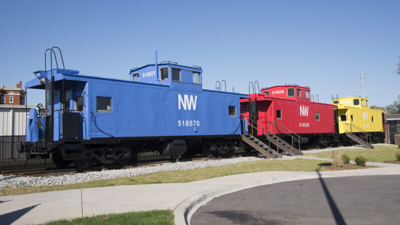 Color photo of blue, red, and yellow cabooses used as apartments.