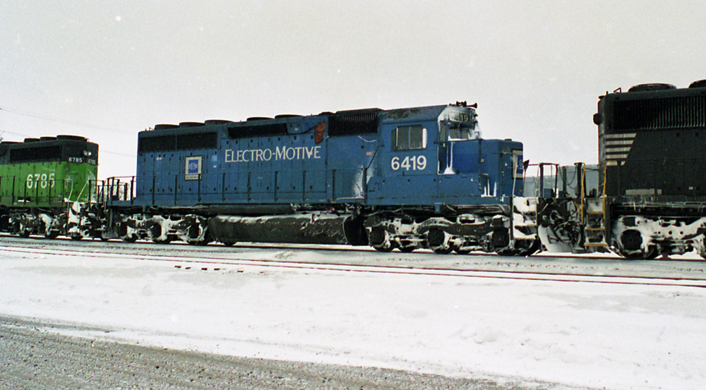 Color photo of blue-and-white diesel in snowy landscape.