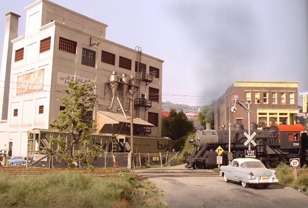 An image of a model railroad layout with a car in the foreground