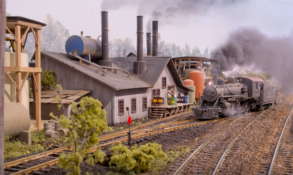 An image of a model railroad layout with a steaming locomotive
