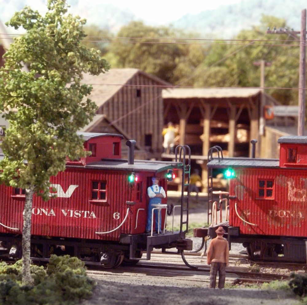 An image of two model cabooses on a railroad