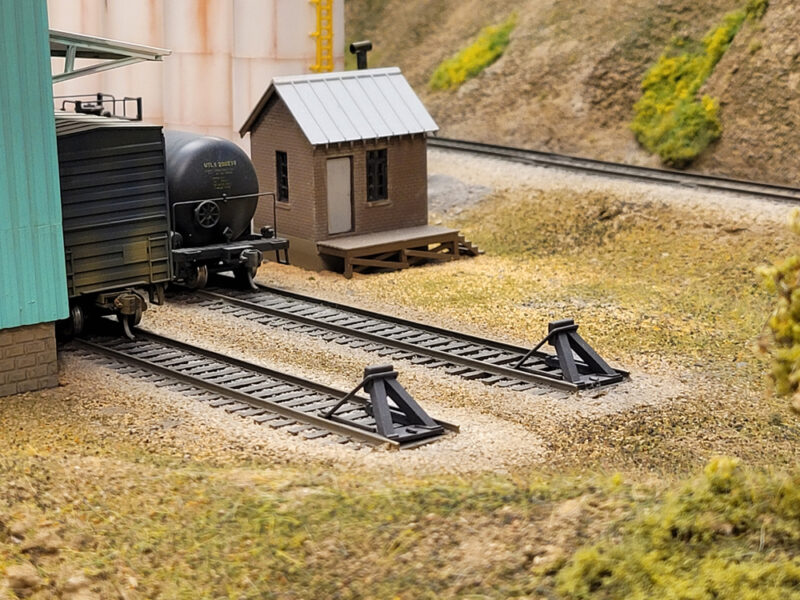 An image of two bumpers at the end of model railroad tracks