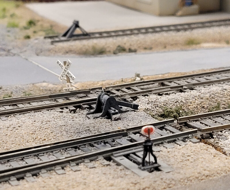 An image showing model rail tracks, switch stands and switch targets