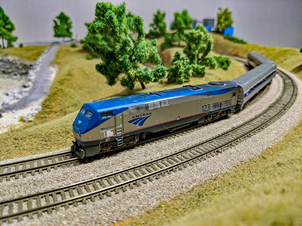 A model of an Amtrak P42DC leads two Amfleet cars around a bend