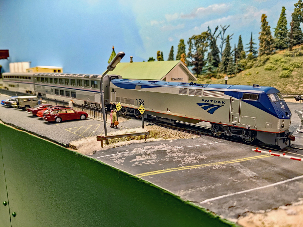 Model of Amtrak diesel engine with two Superliner cars stopped at station