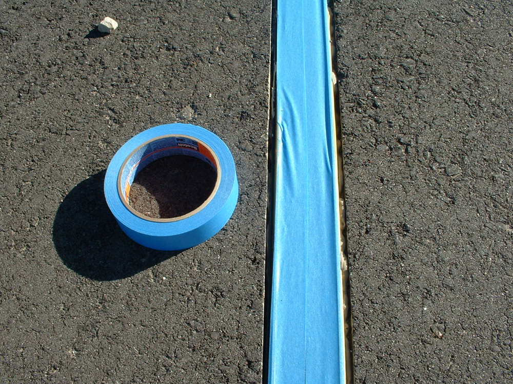 pieces of blue tape over gauge-1 track set in groove