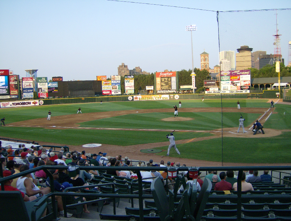Baseball game being played in stadium setting. Fans in stands. High iron baseball — AAA minor league stadiums.