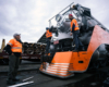 three men in orange safety vests by train