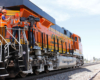 two men preparing camera on side of orange and black diesel