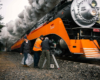 three men by orange and black locomotive