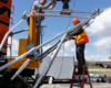 men setting up support system for camera