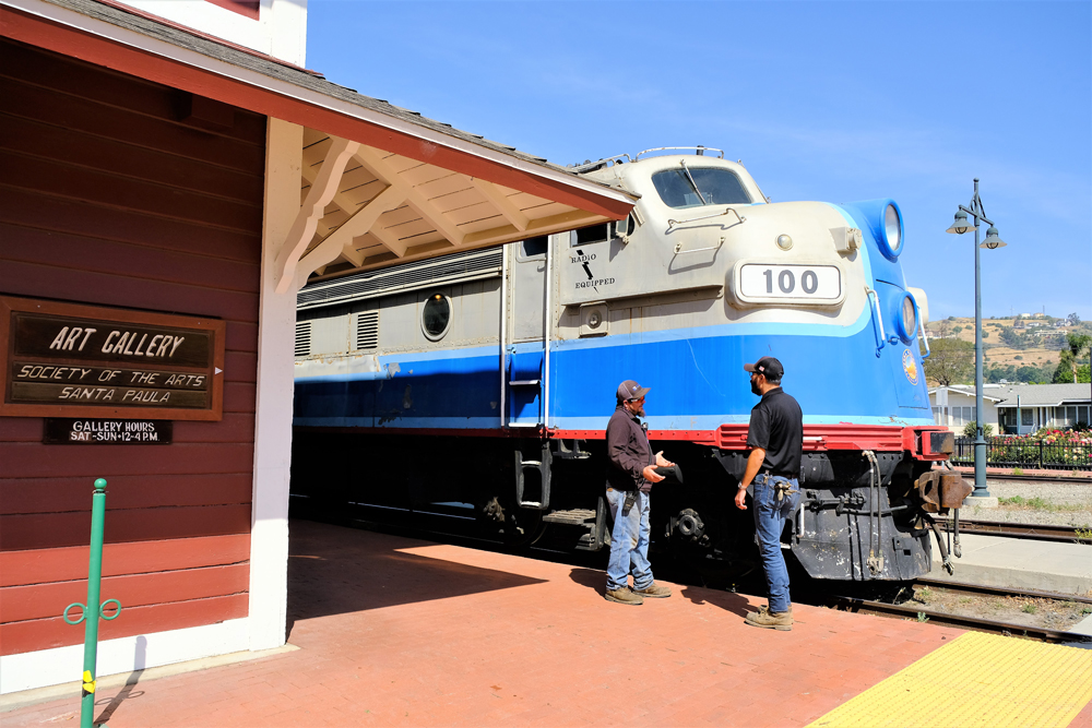 blue and white train by depot