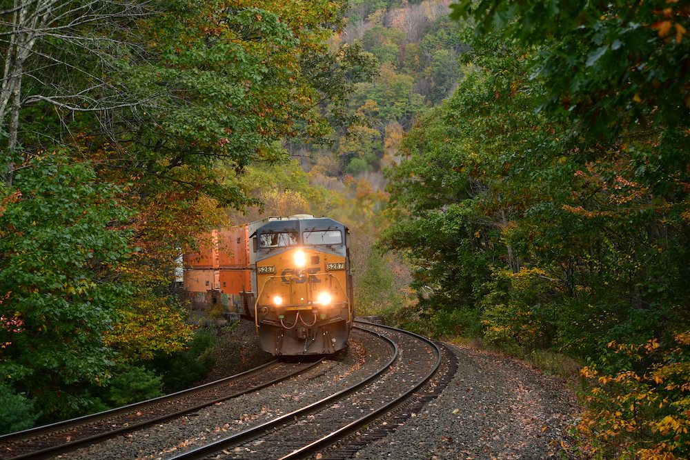 A CSX intermodal freight train descends the Berkshire Mountains surrounded by autumn trees