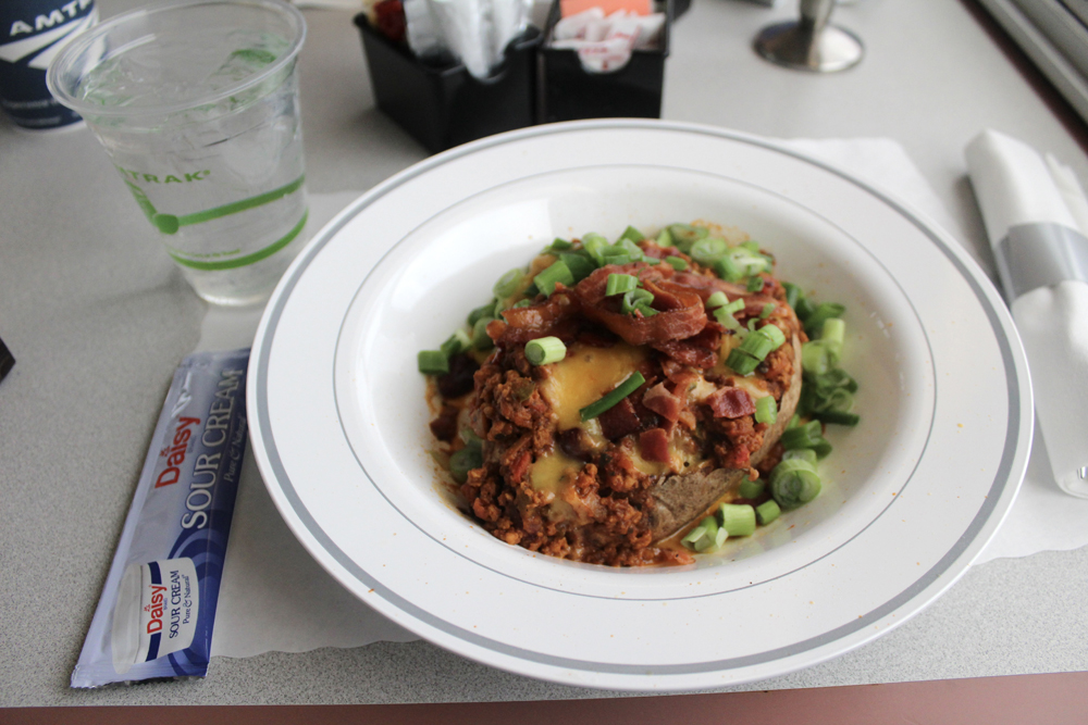 Baked potato covered with toppings in bowl