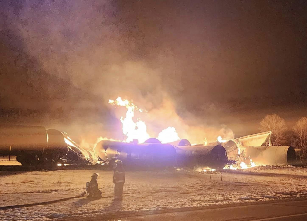 Firefighters watching burning railcars