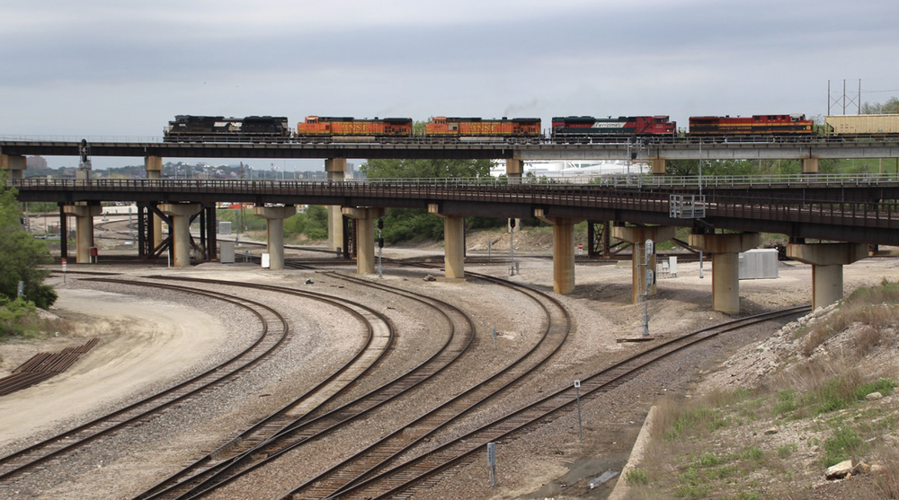 Freight train with five locomotives from three railroads on bridge