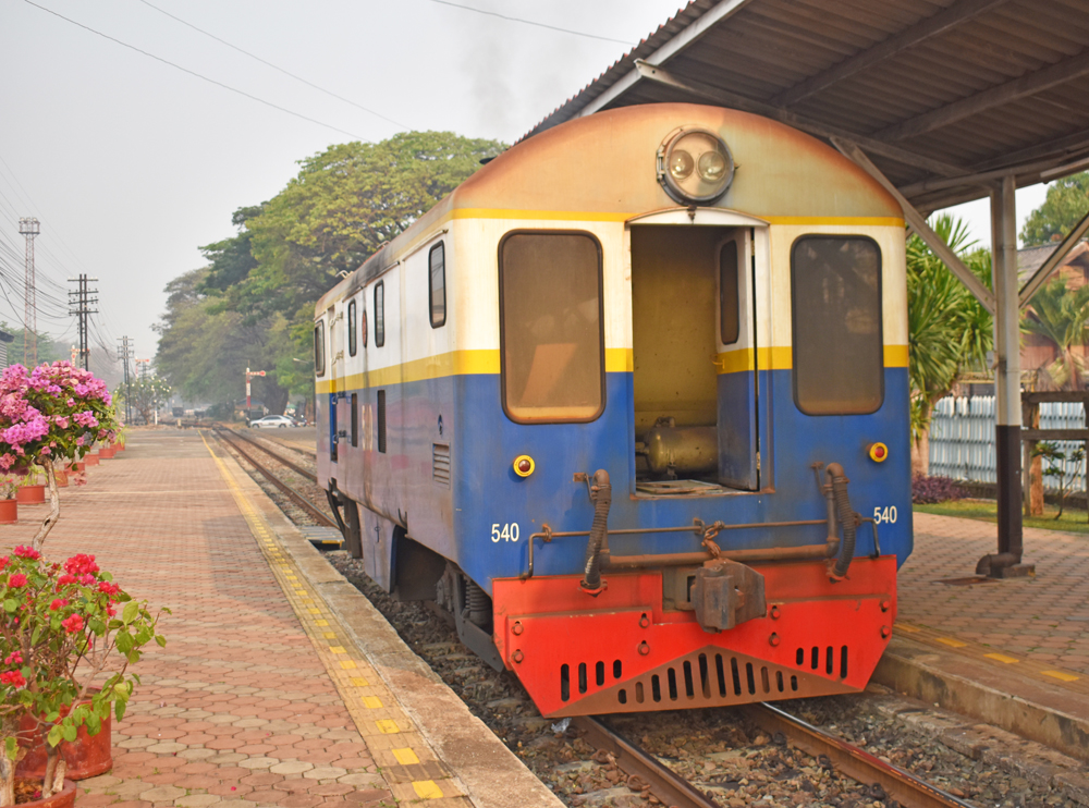 Rear view of blue and tan locomotive with red pilot.