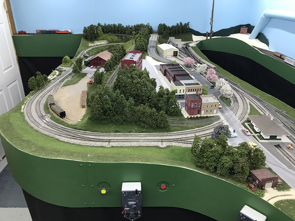 Carolina Sandhills Lines layout: Model train set up featuring green hills and trees as well as gray track that forms a large oval