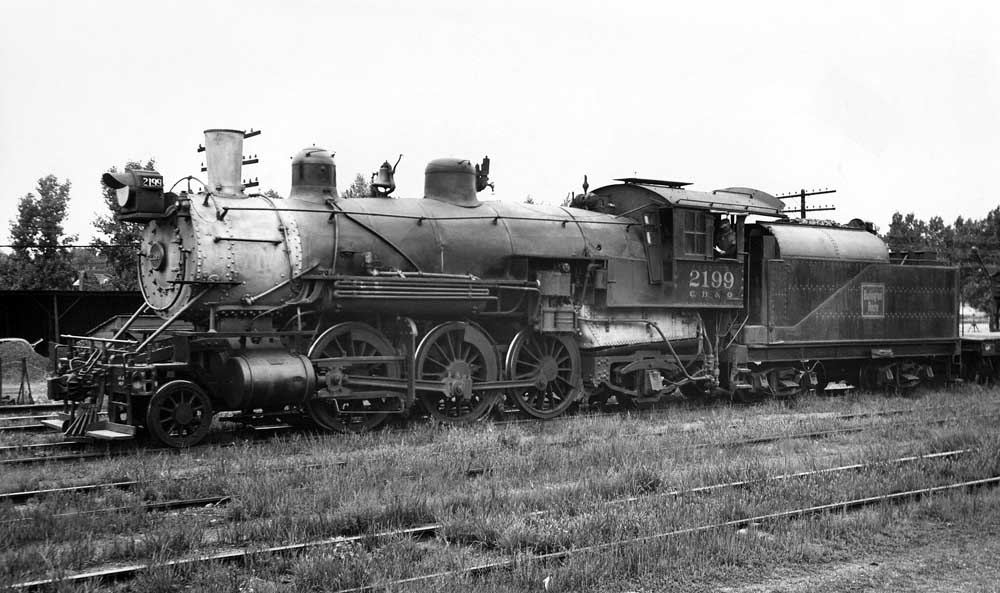 Member of Largest 2-6-2 Prairie fleet parked in grass covered rail yard