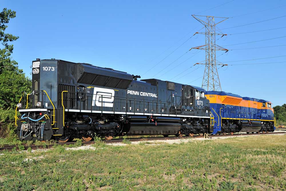 Recreated Penn Central diesel locomotive with blue-and-orange locomotive under power line
