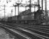 Two electric Penn Central locomotives with freight train under wires