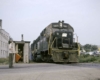 Nose of black-and-white diesel Penn Central locomotives crossing into street