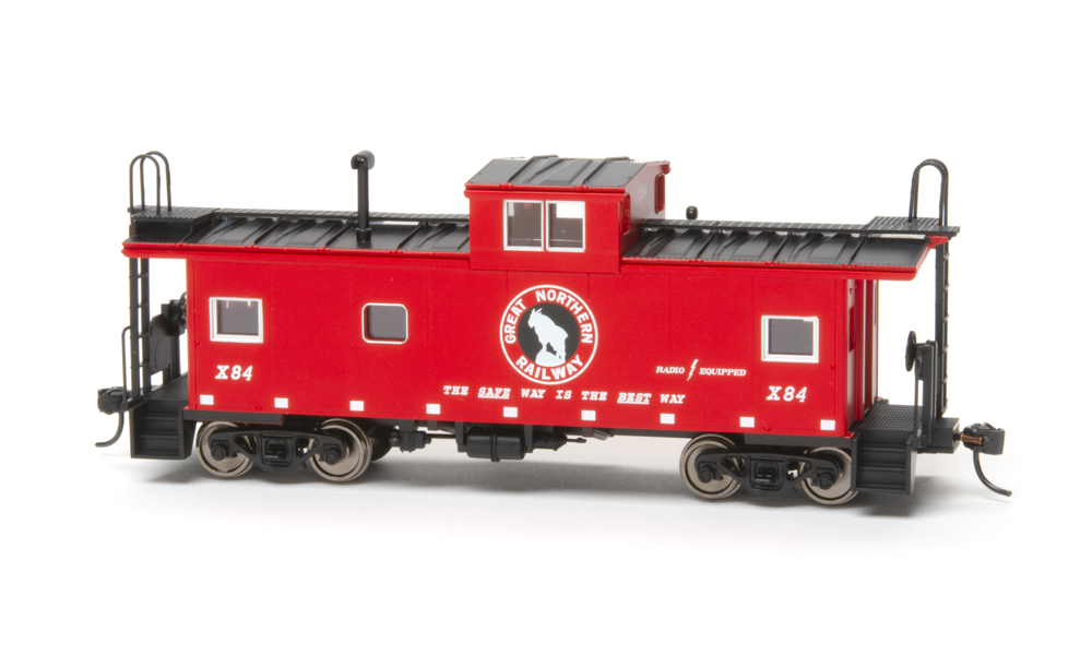 Photo of red and black HO scale caboose on white background