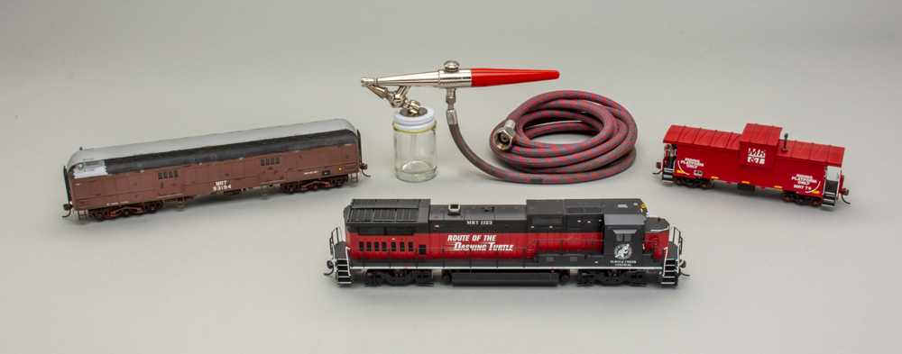 Color photo of airbrush and model trains.