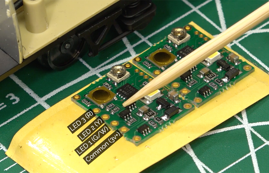 An image of a model train decoder with labelled ground terminals