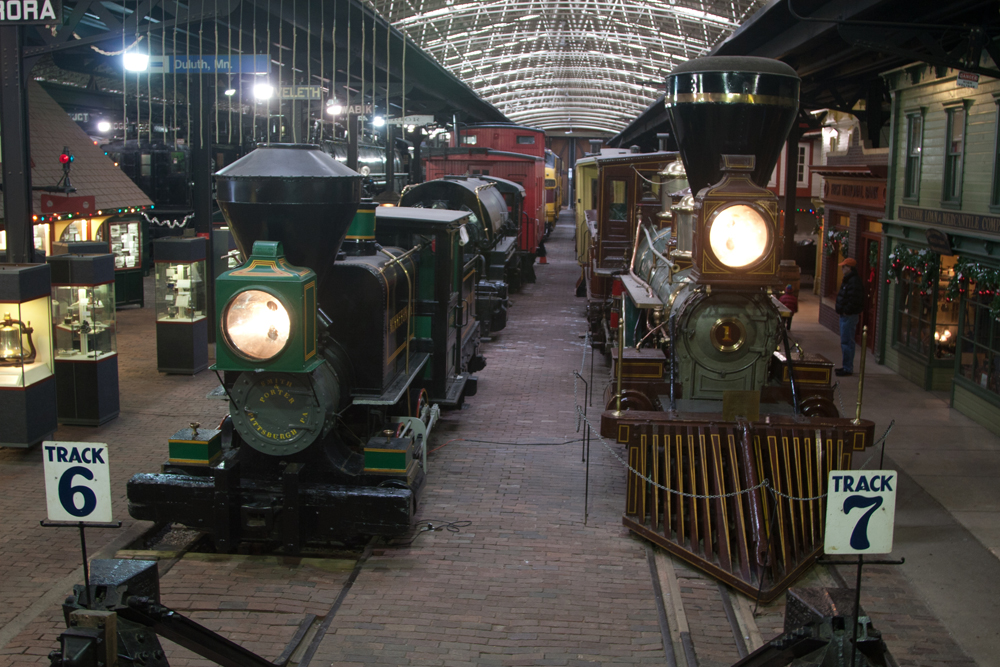 Two small steam locomotives in museum setting.