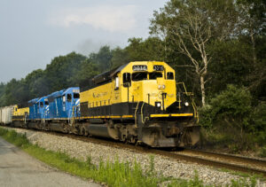 Yellow and black diesel locomotive leading freight train with three other locomotives