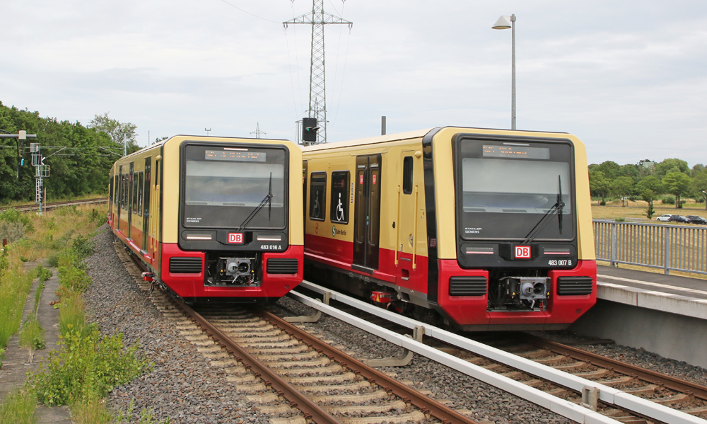 Mustard yellow and red commuter rail equipment.