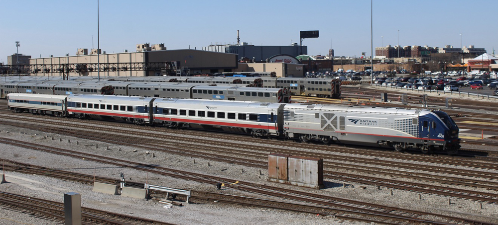 Diesel locomotive and three-car passenger train, with two new Siemens Venture cars immediately behind locomotive