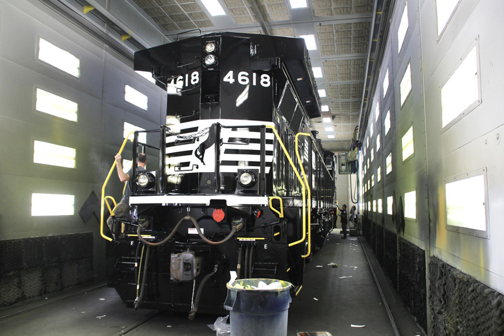 Black and white locomotive in small, well lit enclosure