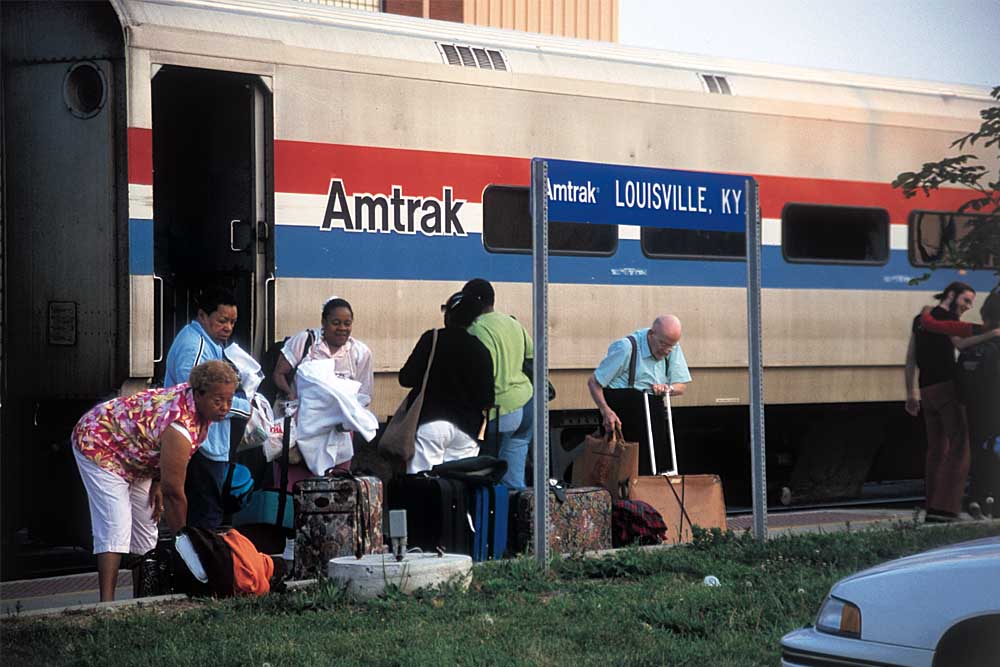 Passengers gather luggage under blue station sign