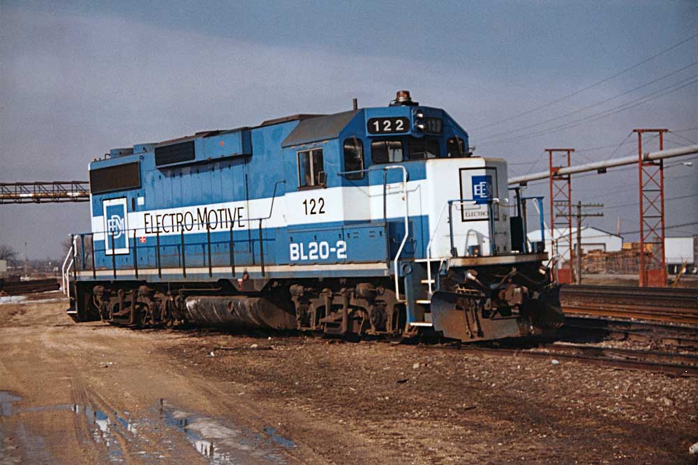 Blue-and-white EMD BL20-2 locomotive standing in yard