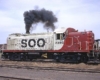 Red-and-white Soo Line diesel locomotive producing smoke