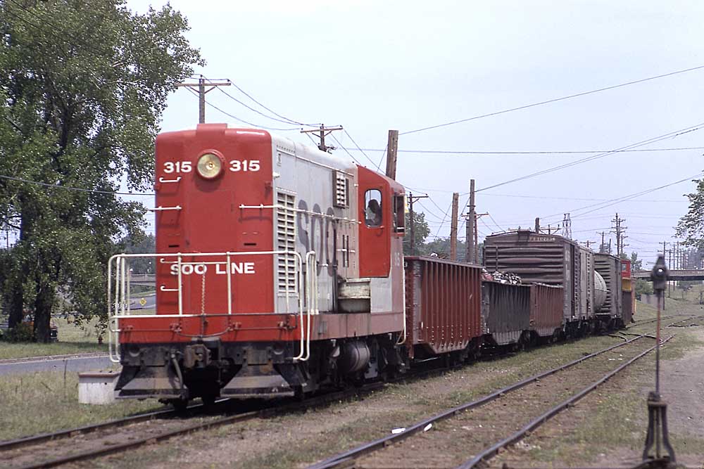 Red-and-white Soo Line diesel locomotive with freight train