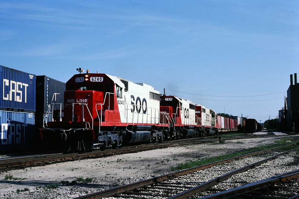 Red-and-white Soo Line diesel locomotives on a freight train