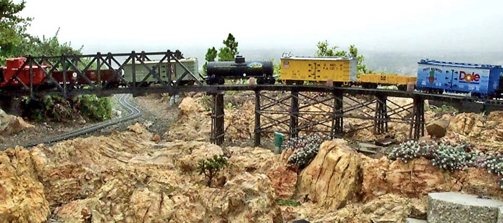 train on trestle crossing rocky area on garden railway