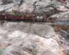 model steam locomotive on track next to large rocks