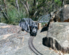 odel steam locomotive on track next to large rocks