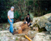 two men next to a model trestle and large rocks