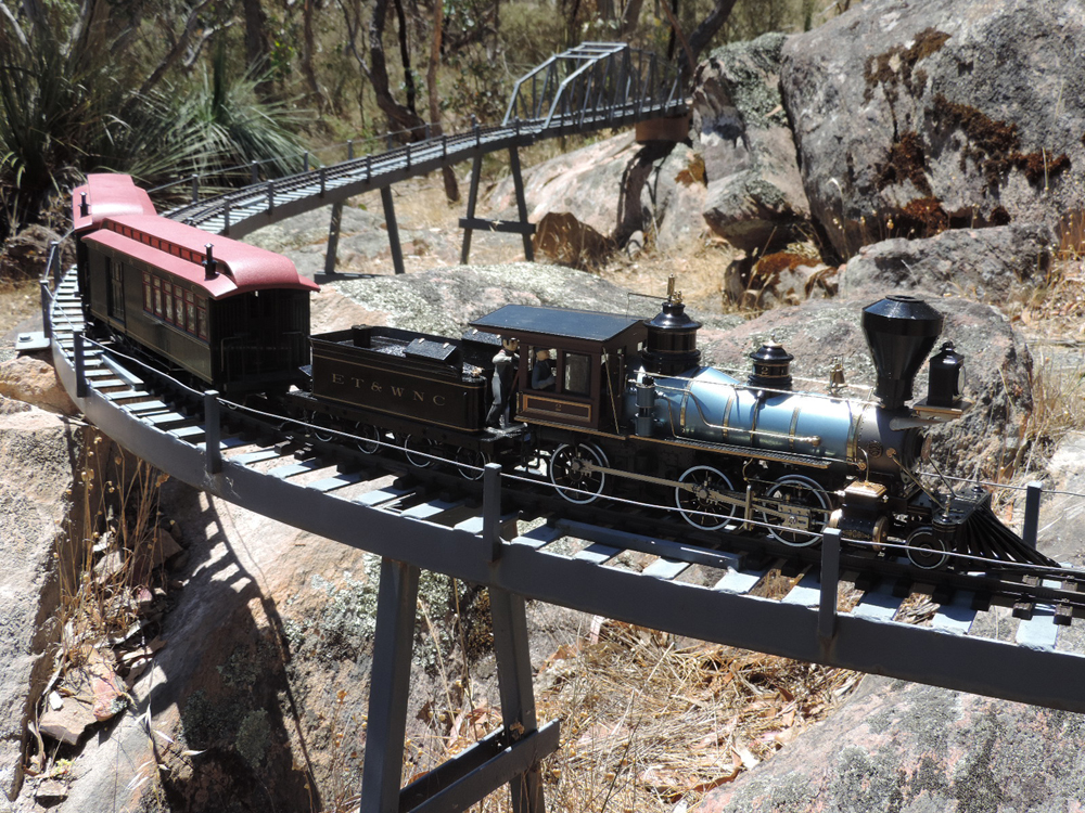 steam locomotive crossing metal bridge