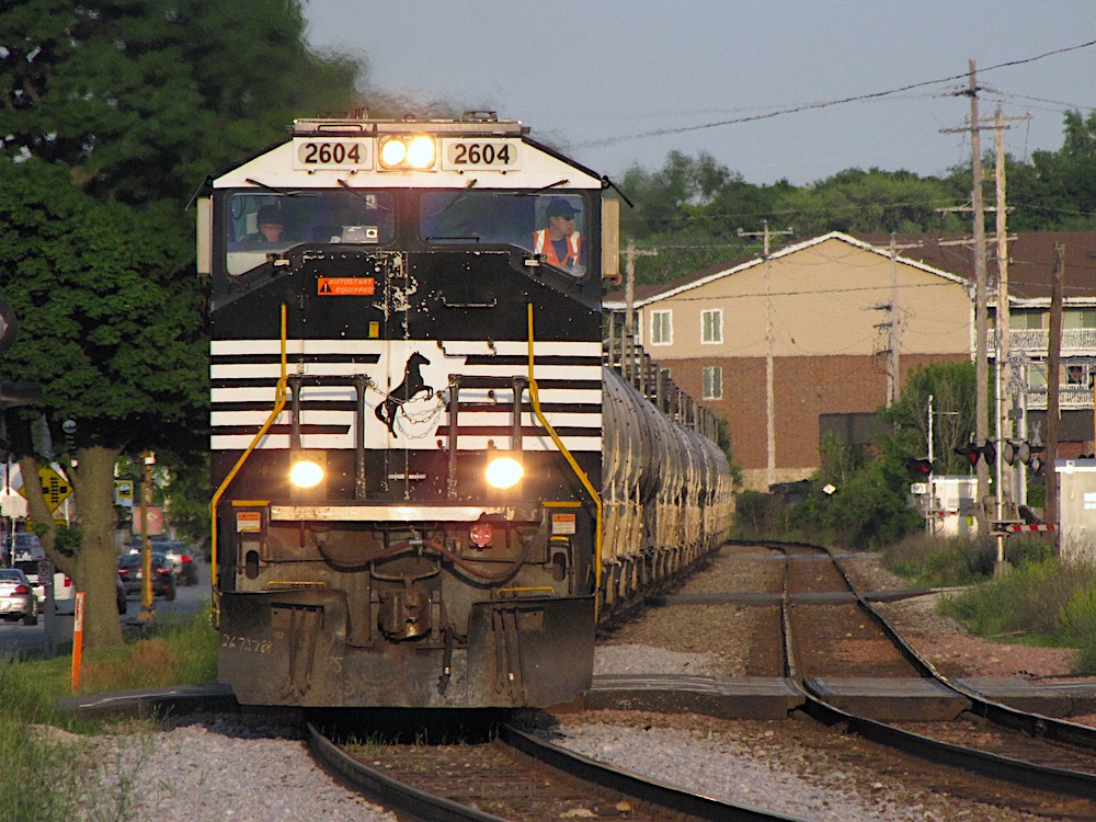 An image of a black-painted modern diesel locomotive leading a long string of tank cars