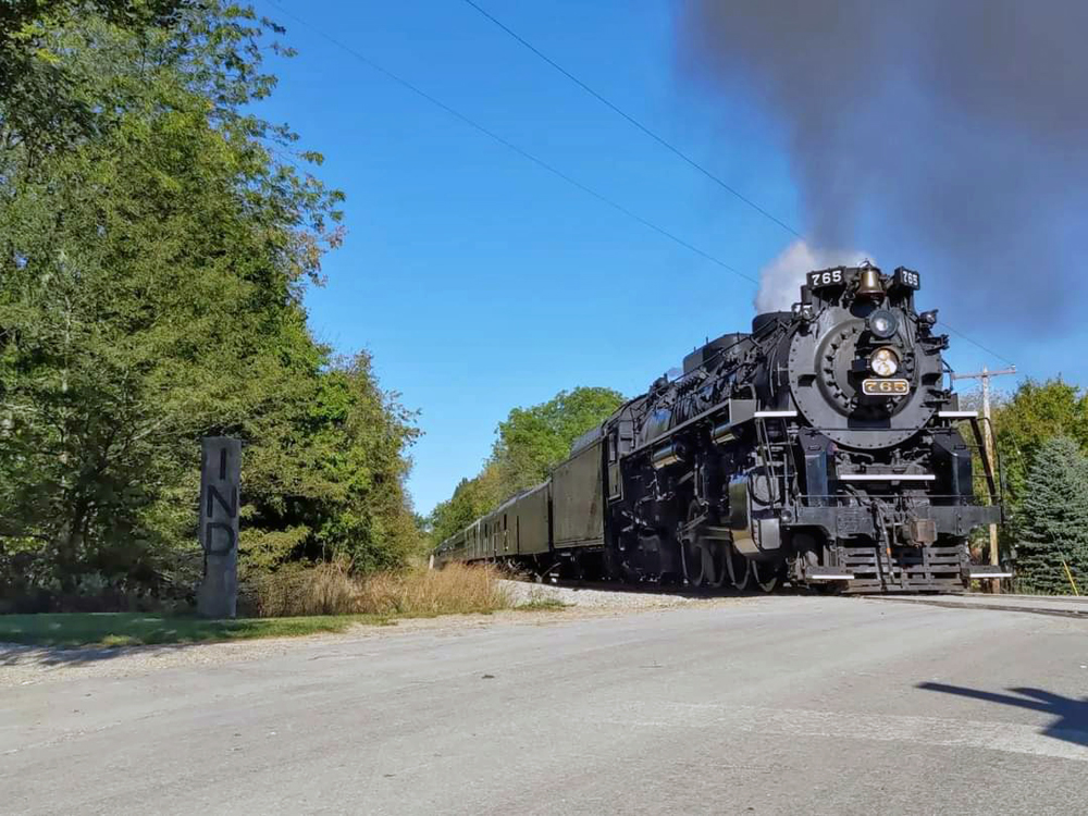 Steam engine crosses railroad crossing
