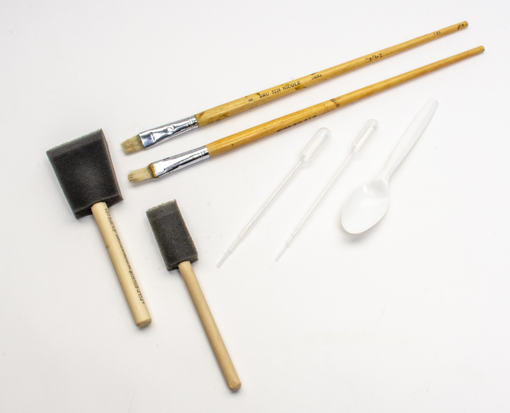 olor photo showing assorted paintbrushes, pipettes, and a spoon.
