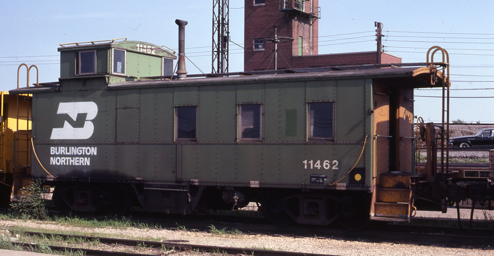 Color photo of steel offset-cupola caboose.