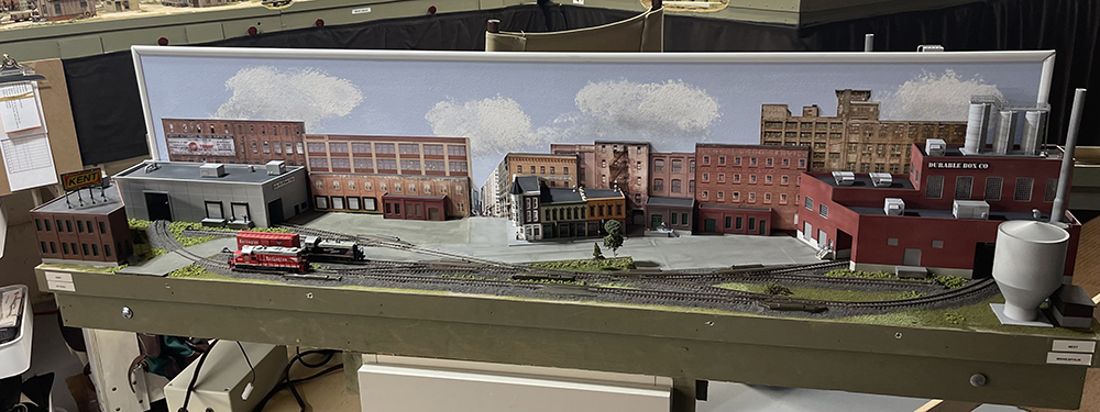 Whiskey Barrel & Grimy Gotham Layout: toy train set up with brown and tan city buildings and concrete streets